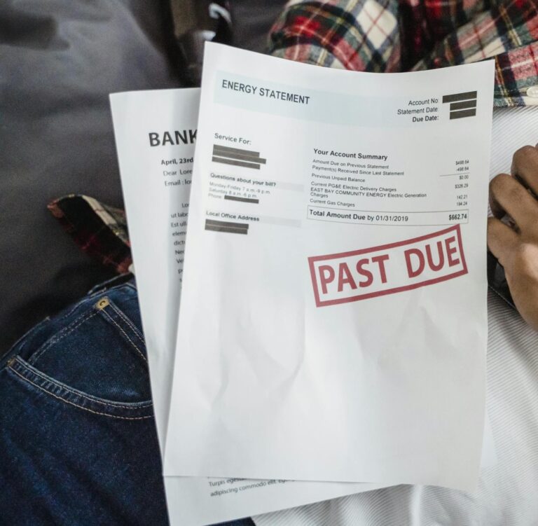 A man relaxes with a beer bottle while holding past due bills, highlighting financial stress.